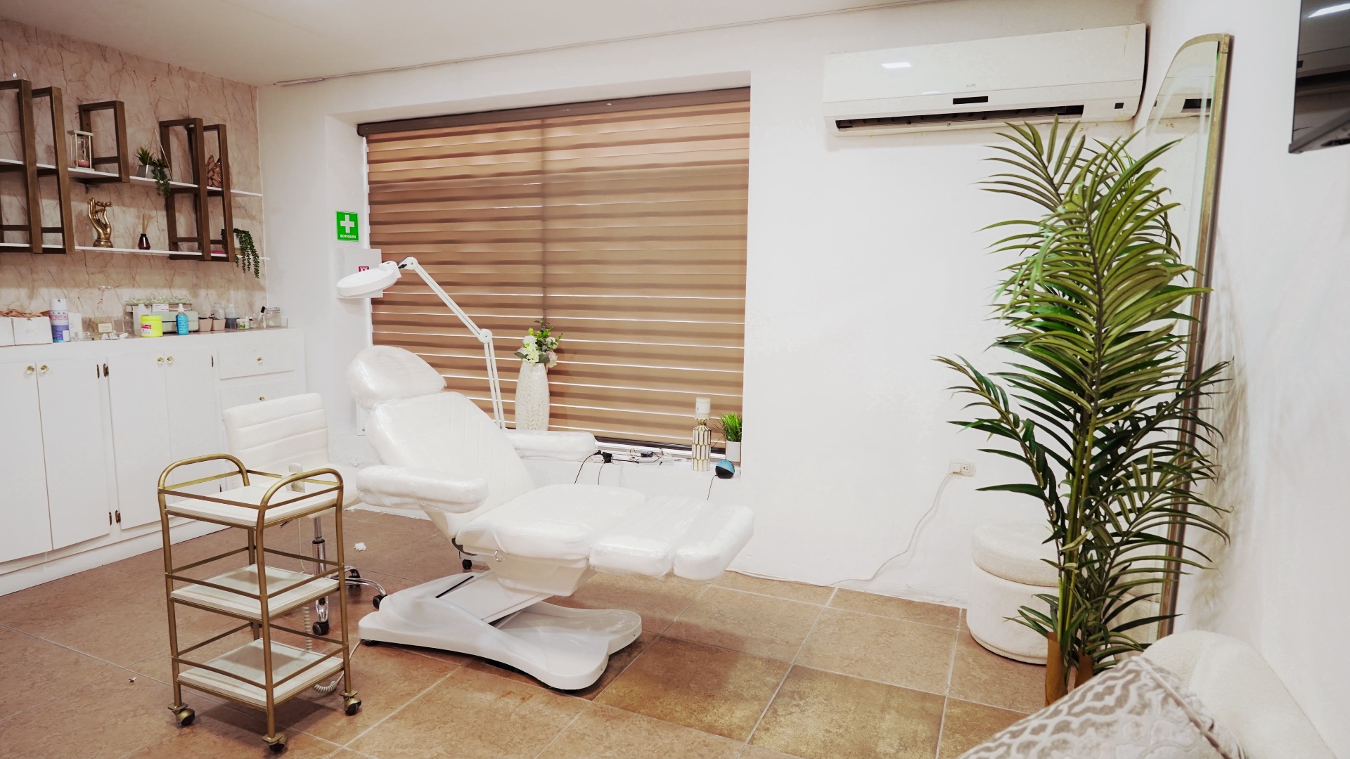 Sala de tratamiento médico-estética moderna con camilla blanca y equipo profesional